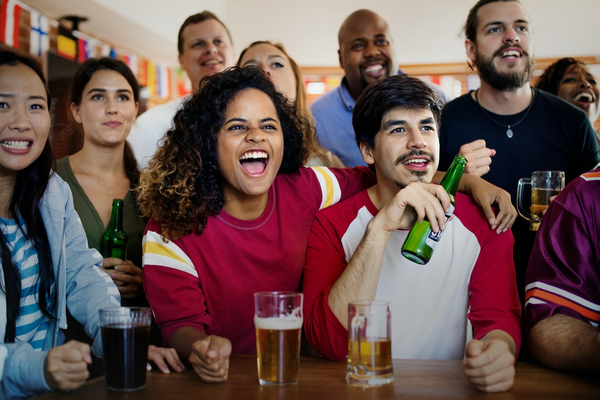 Des supporters de foot qui boivent de la bière dans un bar
